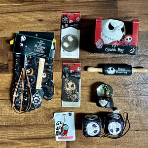 Puede incluir: Una colecci&oacute;n de art&iacute;culos de cocina y decoraci&oacute;n del hogar con personajes de Pesadilla antes de Navidad. Incluye una taza de cer&aacute;mica, manoplas, un rodillo, una bola de nieve y otros accesorios.