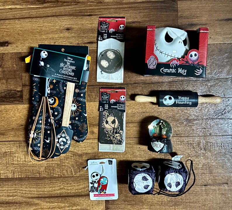 Puede incluir: Una colecci&oacute;n de art&iacute;culos de cocina y decoraci&oacute;n del hogar con personajes de Pesadilla antes de Navidad. Incluye una taza de cer&aacute;mica, manoplas, un rodillo, una bola de nieve y otros accesorios.