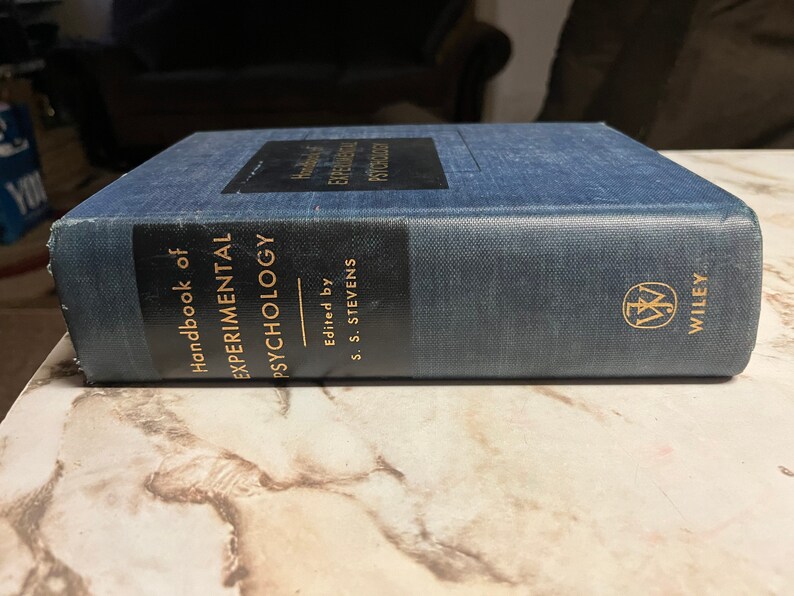 Puede incluir: Un libro de tapa dura azul titulado "Handbook of Experimental Psychology" editado por S. S. Stevens. El libro est&aacute; publicado por Wiley.