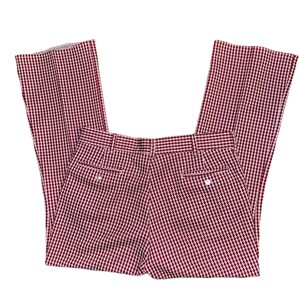 May include: A pair of vintage, high-waisted pants with a flared leg. The pants feature a houndstooth pattern in shades of burgundy and cream. The pants have two back pockets and a button closure.