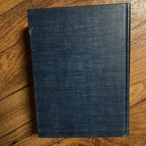 Puede incluir: Un libro de tapa dura de color azul oscuro con una cubierta texturizada.