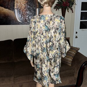 Puede incluir: Un vestido de manga larga con un estampado abstracto colorido. El vestido tiene un corte holgado y un escote redondo. El vestido est&aacute; hecho de una tela suave y fluida.