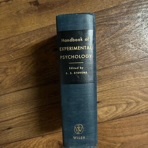 Puede incluir: Un libro de tapa dura de color azul oscuro titulado "Handbook of EXPERIMENTAL PSYCHOLOGY" con el texto "Edited by S. S. STEVENS" y el logotipo de Wiley en la portada.
