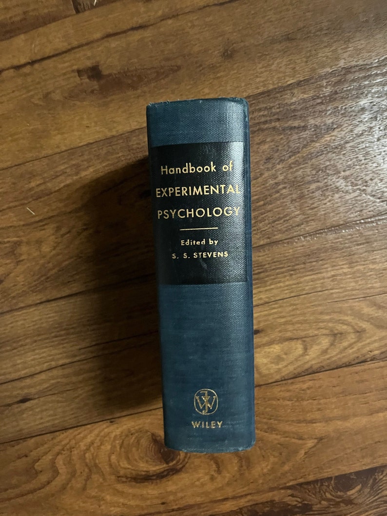 Puede incluir: Un libro de tapa dura de color azul oscuro titulado "Handbook of EXPERIMENTAL PSYCHOLOGY" con el texto "Edited by S. S. STEVENS" y el logotipo de Wiley en la portada.