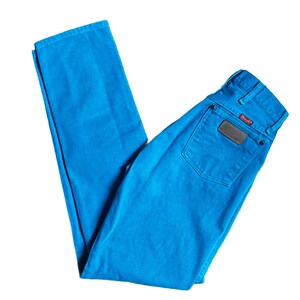 K&ouml;nnte beinhalten: Hellblaue Wrangler-Jeans. Die Jeans haben ein klassisches F&uuml;nf-Taschen-Design, einen braunen Lederaufn&auml;her auf der Ges&auml;&szlig;tasche und das Wrangler-Logo. Die Jeans bestehen aus strapazierf&auml;higem Denim-Material.