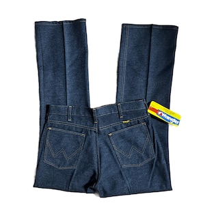 Może przedstawiać: Ciemnoniebieskie dżinsy Wrangler z klasycznym pięciokieszeniowym designem. Dżinsy mają prosty kr&oacute;j nogawek i logo Wrangler na tylnej kieszeni oraz ż&oacute;łto-czerwoną metkę. Dżinsy są nowe.