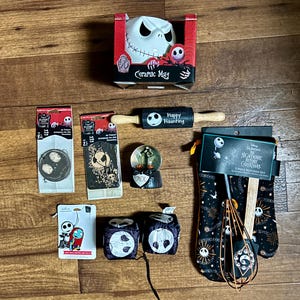 Puede incluir: Una colecci&oacute;n de art&iacute;culos para el hogar y la cocina con tem&aacute;tica de Pesadilla antes de Navidad. Los art&iacute;culos incluyen una taza de cer&aacute;mica, un rodillo, una bola de nieve, guantes de cocina y un juego de cocina de 3 piezas.