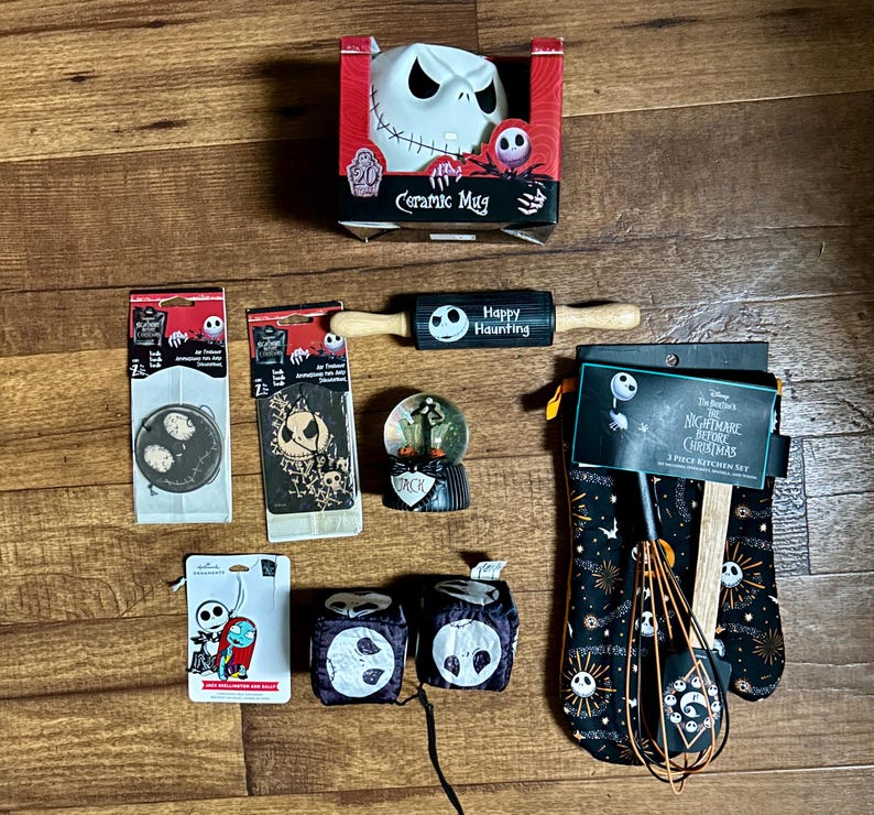 Puede incluir: Una colecci&oacute;n de art&iacute;culos para el hogar y la cocina con tem&aacute;tica de Pesadilla antes de Navidad. Los art&iacute;culos incluyen una taza de cer&aacute;mica, un rodillo, una bola de nieve, guantes de cocina y un juego de cocina de 3 piezas.