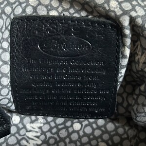 May include: Black leather tag with white text that reads "The Brighton Collection. All leathers are individually selected for China Moon quality leather. Any markings on the surface are part of the natural beauty, texture and character of the leather, which makes each piece unique."