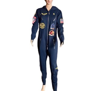 May include: A navy blue flight suit jumpsuit featuring a front zipper closure, a hood, and multiple embroidered patches on the chest and sleeves. The patches include aviation-themed designs, a United States flag, and gold star accents on the leg.