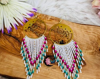 May include: A pair of long, beaded earrings with a gold filigree design. The beads are white, pink, and green.
