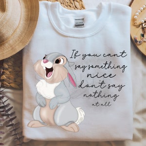 May include: White sweatshirt featuring a cartoon rabbit with the text "If you can't say something nice don't say nothing at all." The rabbit is gray, pink, and beige. The text is in black script.