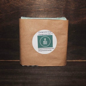 May include: A bar of soap wrapped in brown paper. A white circular sticker with the text "Change your soap. Change your life!" and the shop name "M&CO SOAP" is on the front. The Etsy shop URL is also visible.