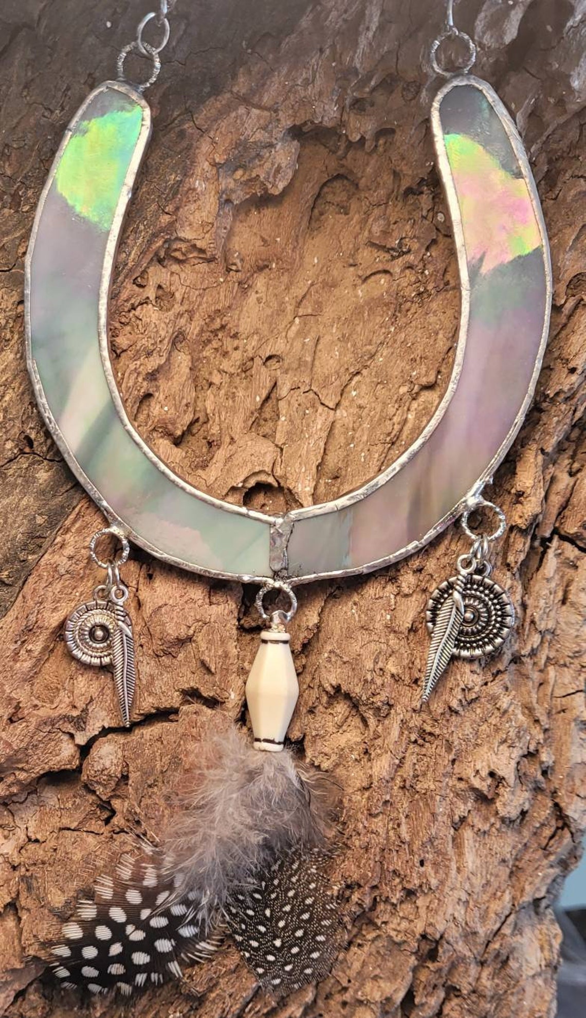 Stained glass horseshoe with feather and charm accents. Etsy