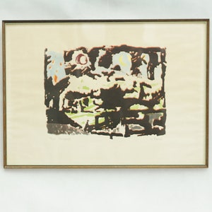 May include: A framed abstract print with a gold frame. The print is a collage of different colors and shapes, including brown, green, yellow, and red. The print is on a white background.