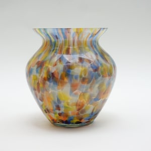 May include: A colorful glass vase with a mottled, striped pattern in shades of blue, yellow, orange, and brown.