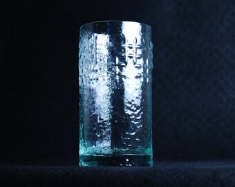 Op de afbeelding: Een heldere glazen tumbler met een getextureerd oppervlak. Het glas heeft een lichtgroene tint.