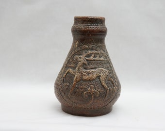 Peut inclure: Un vase en céramique brun avec un motif en relief d'un cerf dans une scène de forêt.