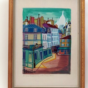 May include: A colorful painting of a Parisian street scene with buildings, a church, and a street lamp. The painting is signed "maurice blanchard" and titled "La Ville Perdue de Saint Germain".