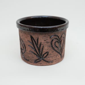 May include: A set of three ceramic mugs with a speckled, matte finish. The mugs are in shades of cream, light gray, and dark gray. Each mug has a simple, minimalist design and a rounded handle.