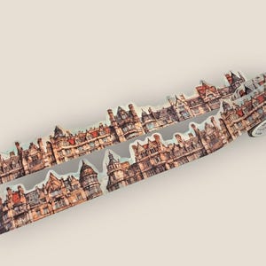 May include: Washi tape with a repeating pattern of detailed buildings in a vintage style. The tape roll shows a cityscape with brown, beige, and red tones, ideal for crafts and scrapbooking projects.