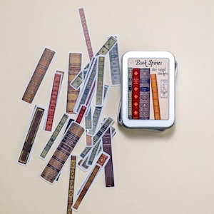 May include: A tin of 60 colorful book spine stickers. The tin is silver with a white label that says "Book Spines 60 washi stickers".