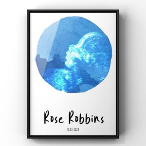 May include: Framed art print featuring a watercolor-style blue circle with an ultrasound image. The print includes the name "Rose Robbins" and the date "12.03.2020" in black script.