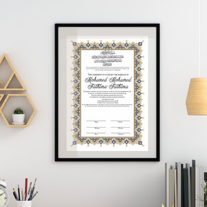 May include: A framed Islamic marriage certificate with blue and gold ornate borders. The text reads "This agreement is to certify the marriage of Mohamed Mohamed Fathima Fathima".