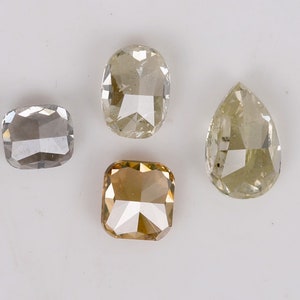 Puede incluir: Cuatro diamantes sueltos de diferentes formas y colores. Un diamante en forma de pera, un diamante cuadrado, un diamante rectangular y un diamante ovalado.