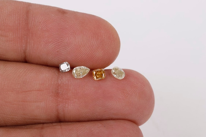 Puede incluir: Cinco diamantes sueltos de diferentes formas y tama&ntilde;os. Un diamante cuadrado, un diamante en forma de pera, un diamante cuadrado, un diamante en forma de pera y un diamante en forma de pera.
