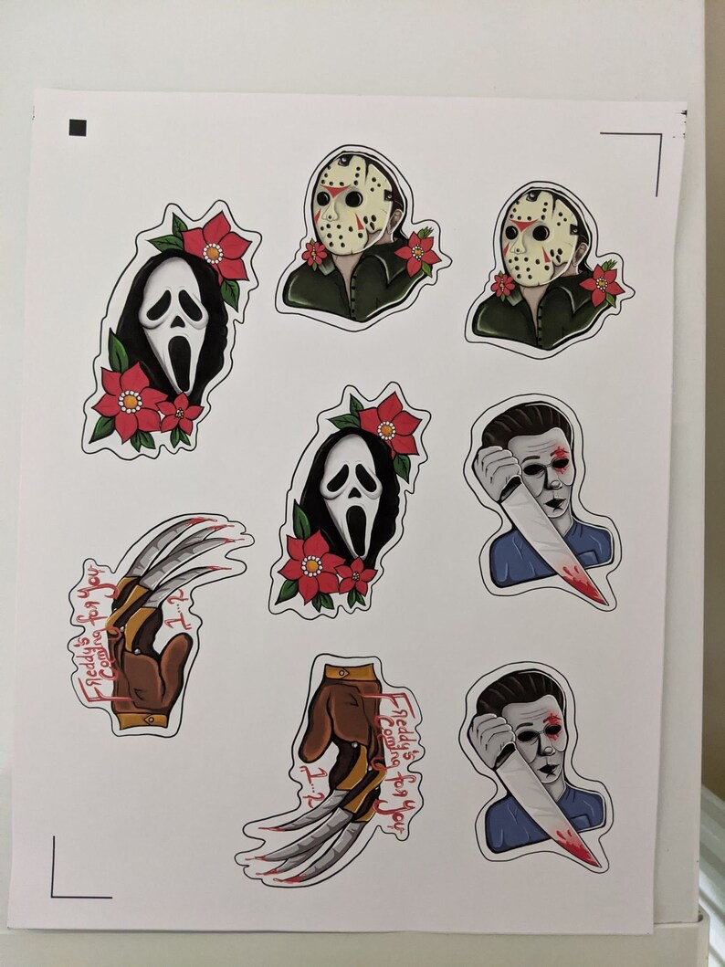 K&ouml;nnte beinhalten: Acht Horrorfilm-Charakter-Aufkleber mit Freddy Krueger, Jason Voorhees und Ghostface. Die Aufkleber sind auf wei&szlig;em Papier gedruckt und zeigen rote und wei&szlig;e Stechpalmenmotive.