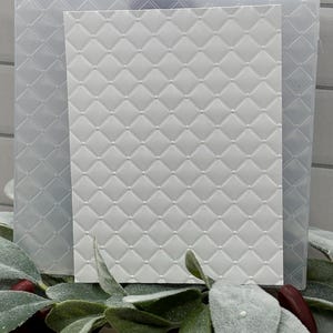 Op de afbeelding: Een rechthoekige witte embossing folder met een verhoogd ruitpatroon met kleine cirkelvormige stippen op elk snijpunt. De plastic map is doorschijnend en heeft een getextureerd oppervlak dat is ontworpen voor een geometrisch patroon.