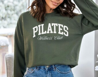 May include: A green sweatshirt with the text "PILATES Wellness Club" in white lettering.