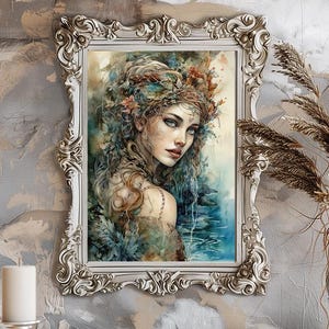 Puede incluir: Pintura en acuarela enmarcada de una mujer con cabello largo y suelto y una corona floral. La obra de arte presenta tonos fríos de azul y verde, enmarcada en un marco ornamentado de color blanco roto. La pintura está montada en una pared gris texturizada.
