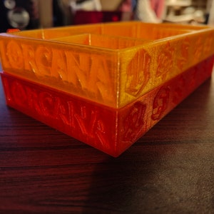 May include: Two stacked orange and red plastic storage boxes with the word "ORGANIZE" embossed on the front of each box.