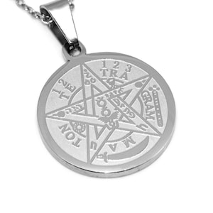 May include: Silver pendant necklace featuring a five-pointed star design with the inscription "1 2 3 TRA GRAM TON" around the edge.