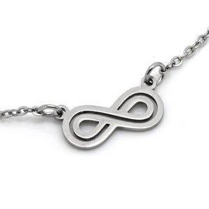 Peut inclure: Un collier en argent avec un symbole infini et une chaîne délicate.