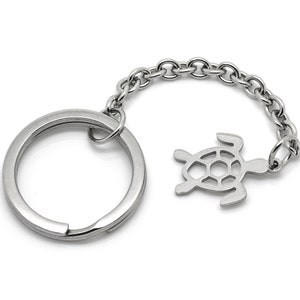 Puede incluir: Llavero de plata con un dije de tortuga. La cadena está unida a un llavero de plata.