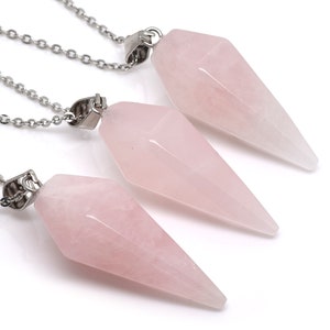 Può includere: Tre ciondoli in cristallo di quarzo rosa su catene d'argento. I ciondoli hanno la forma di una punta e sono di colore rosa chiaro.