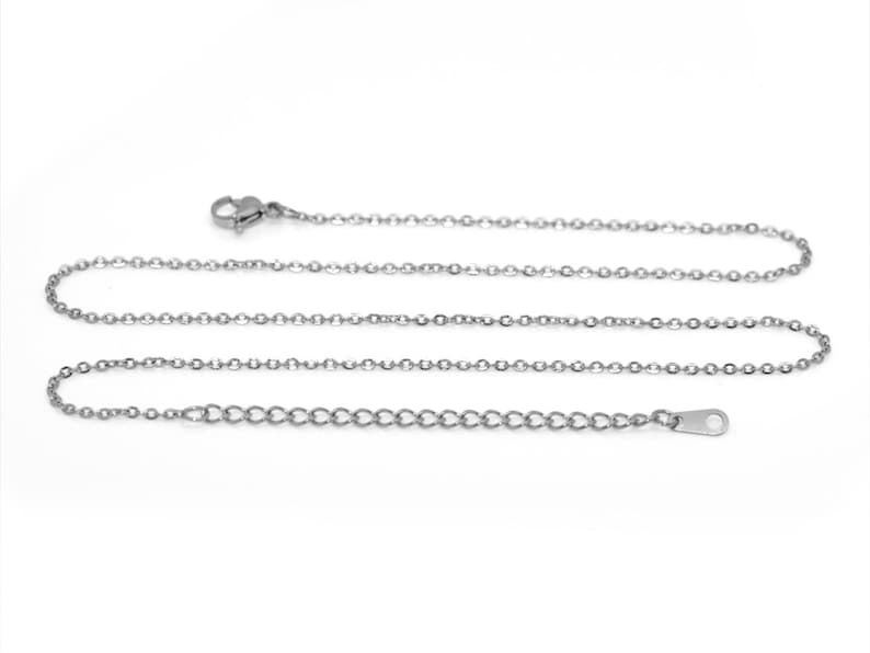 May include: A silver chain necklace with a lobster clasp and an extension chain.
