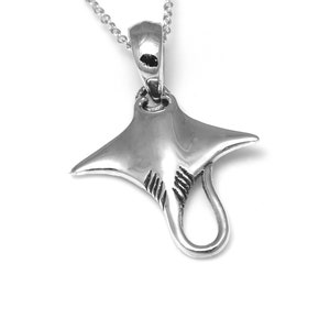 Puede incluir: Un collar con un colgante de plata con un diseño de raya manta tridimensional.