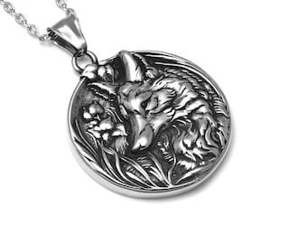 May include: A silver pendant necklace featuring a detailed, three-dimensional design of a wolf's head surrounded by foliage.