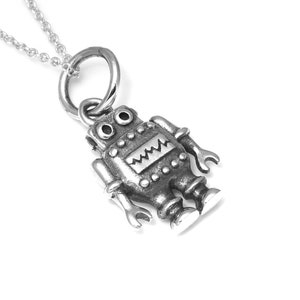Op de afbeelding: Een zilveren robot hangerketting. De robot staat met zijn armen uitgestrekt en heeft een klein, rond hoofd met twee ogen. De hanger is bevestigd aan een zilveren ketting.