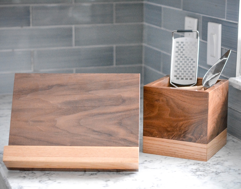 May include: A wooden kitchen utensil holder with a grater and a wooden chopping board.
