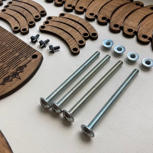 May include: A collection of wooden components, including a comb-like piece and curved pieces, alongside metal screws, nuts, and small black switches. The wooden parts have a dark brown finish, and the metal hardware is silver.