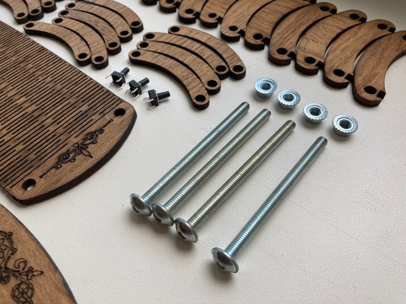May include: A collection of wooden components, including a comb-like piece and curved pieces, alongside metal screws, nuts, and small black switches. The wooden parts have a dark brown finish, and the metal hardware is silver.