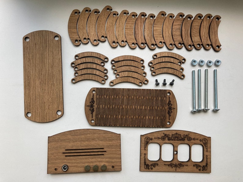 May include: A disassembled wooden craft kit with various components. The kit includes rectangular and curved wooden pieces, screws, nuts, and bolts. The wood has a natural brown color. Some pieces have decorative etched designs. The components are arranged on a white surface.