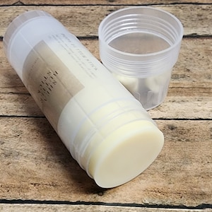 May include: A white deodorant stick in a clear plastic container with a brown label that reads "Deodorant Stick" and "Wild Sage & Mint".