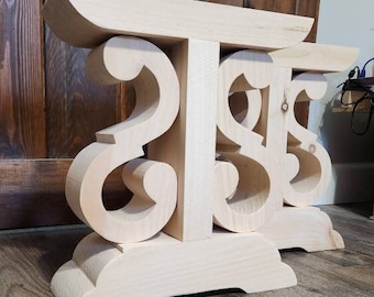 May include: Two unfinished wooden table legs with a decorative scroll design. The legs are made of light-colored wood and have a simple, elegant style.