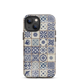 Può includere: Una custodia per smartphone con un motivo ripetuto di piastrelle blu e bianche. Il design include motivi floreali e geometrici, con una grafica di uccelli su alcune piastrelle. La custodia ha un modulo fotocamera nero.